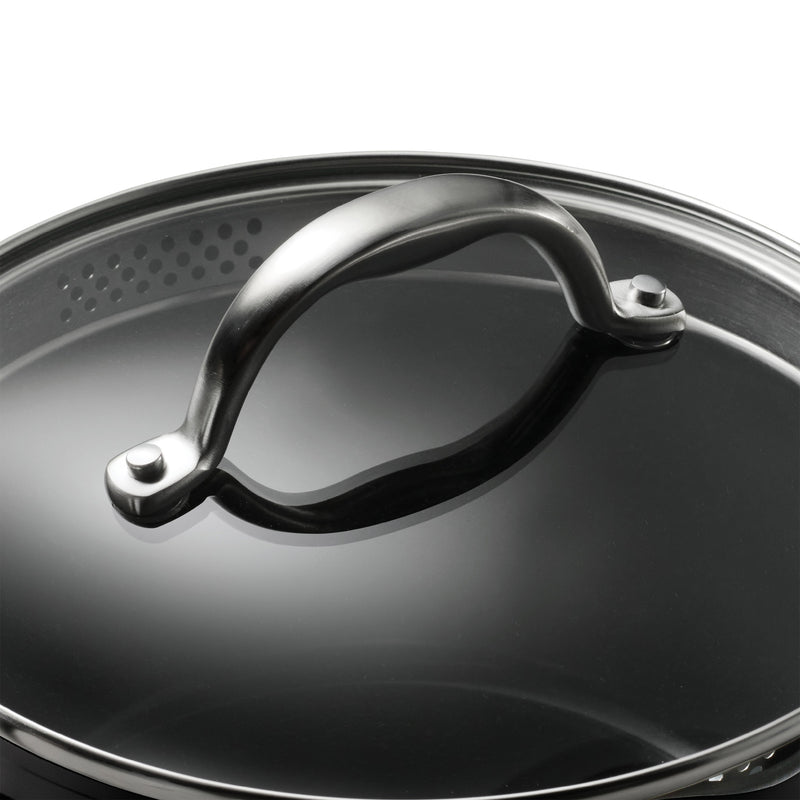 Close-up of a black pot lid with a metallic handle on a white background