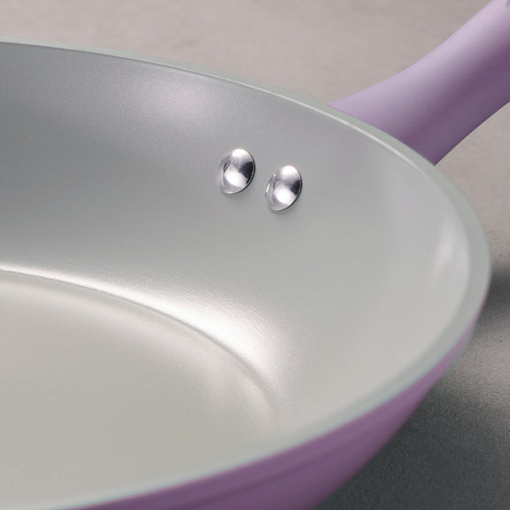 Closeup of riveted handle on a purple frying 