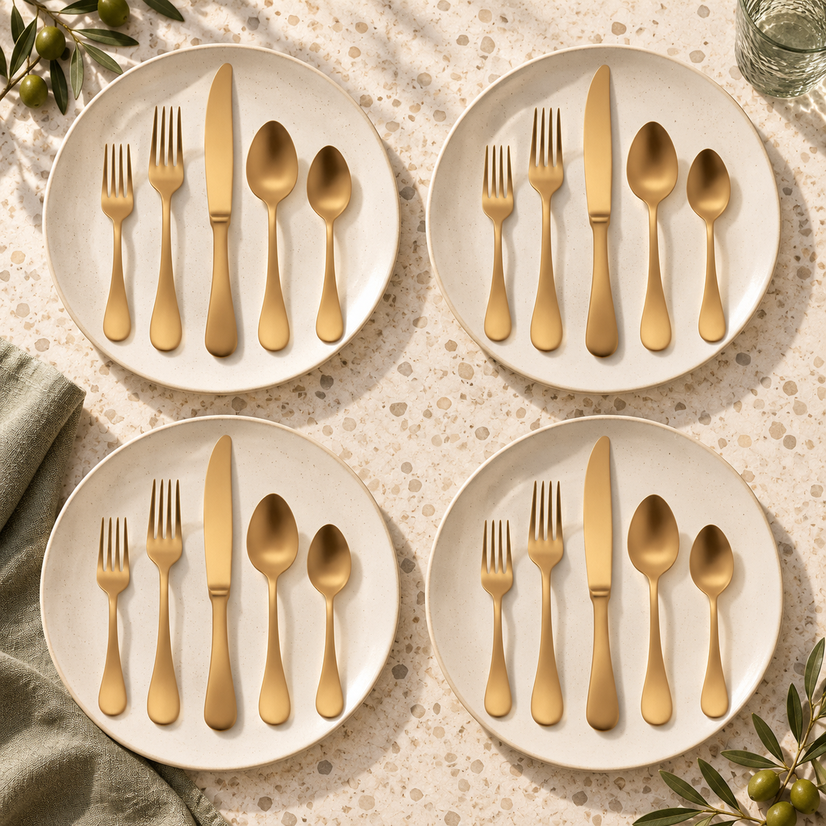 Mepra Brescia Oro Ice 20-piece brushed gold flatware arranged as four warm daylight place settings