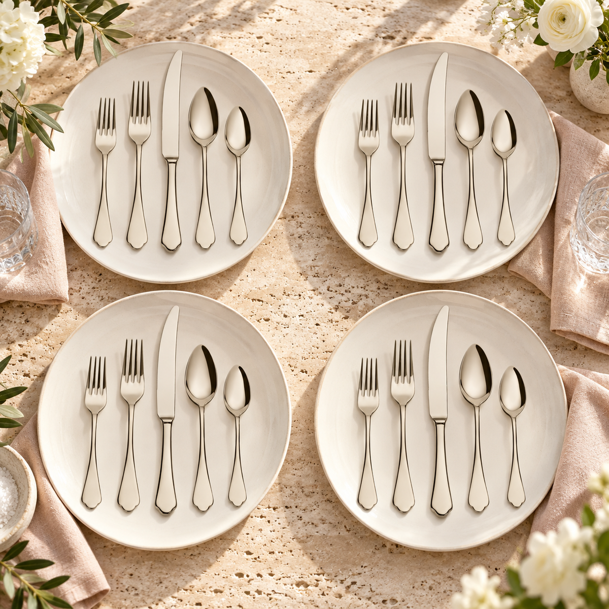 Mepra Dolce Vita Champagne 20-piece flatware arranged as four sunlit travertine-table place settings