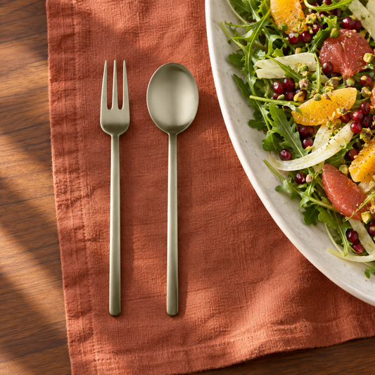 Mepra Due Ice Champagne brushed hostess spoon and fork beside citrus salad