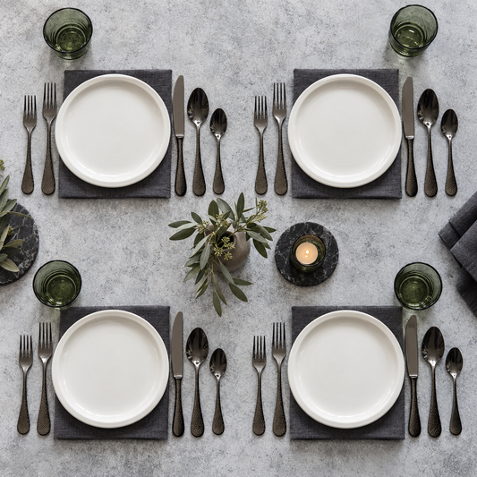 Mepra Epoque Oro Nero 20-piece hammered dark flatware arranged for four modern place settings