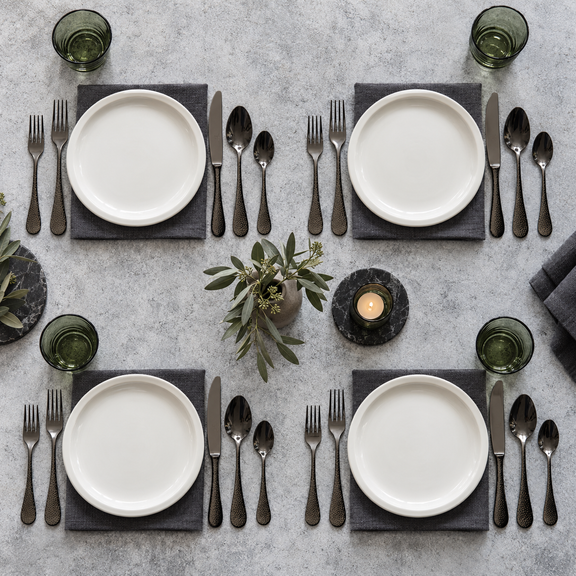 Mepra Epoque Oro Nero 20-piece hammered dark flatware arranged for four modern place settings