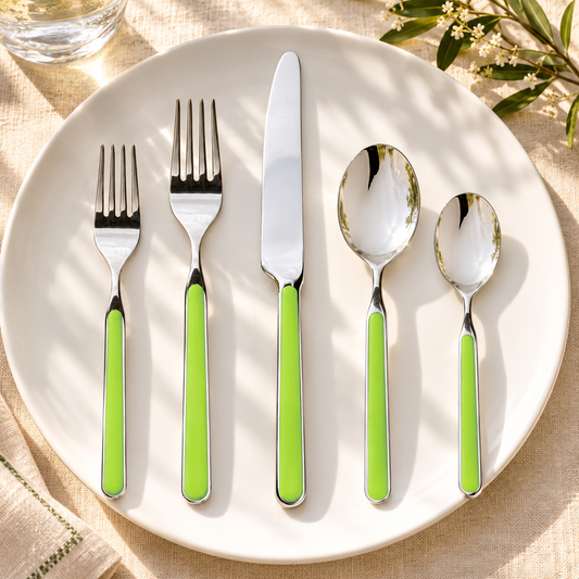 Mepra Fantasia Acid Green five-piece flatware on cream linen and white plate