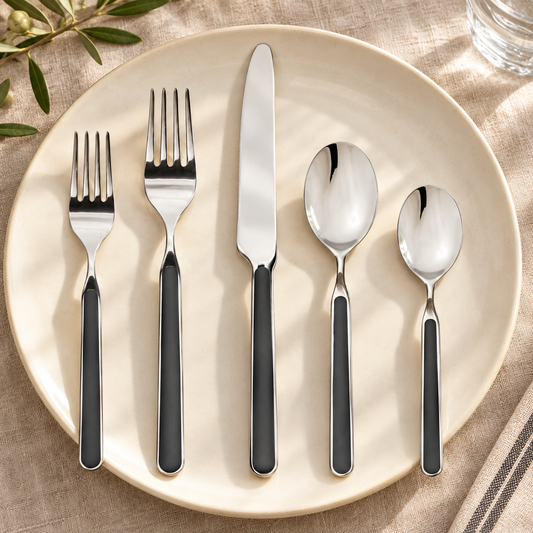 Mepra Fantasia Black five-piece flatware with silver heads and black handles on warm linen