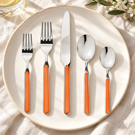 Mepra Fantasia Carrot five-piece flatware with orange handles on ivory linen