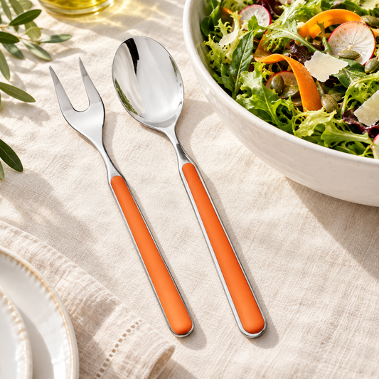 Mepra Fantasia Carrot two-piece salad servers with orange handles on ivory linen