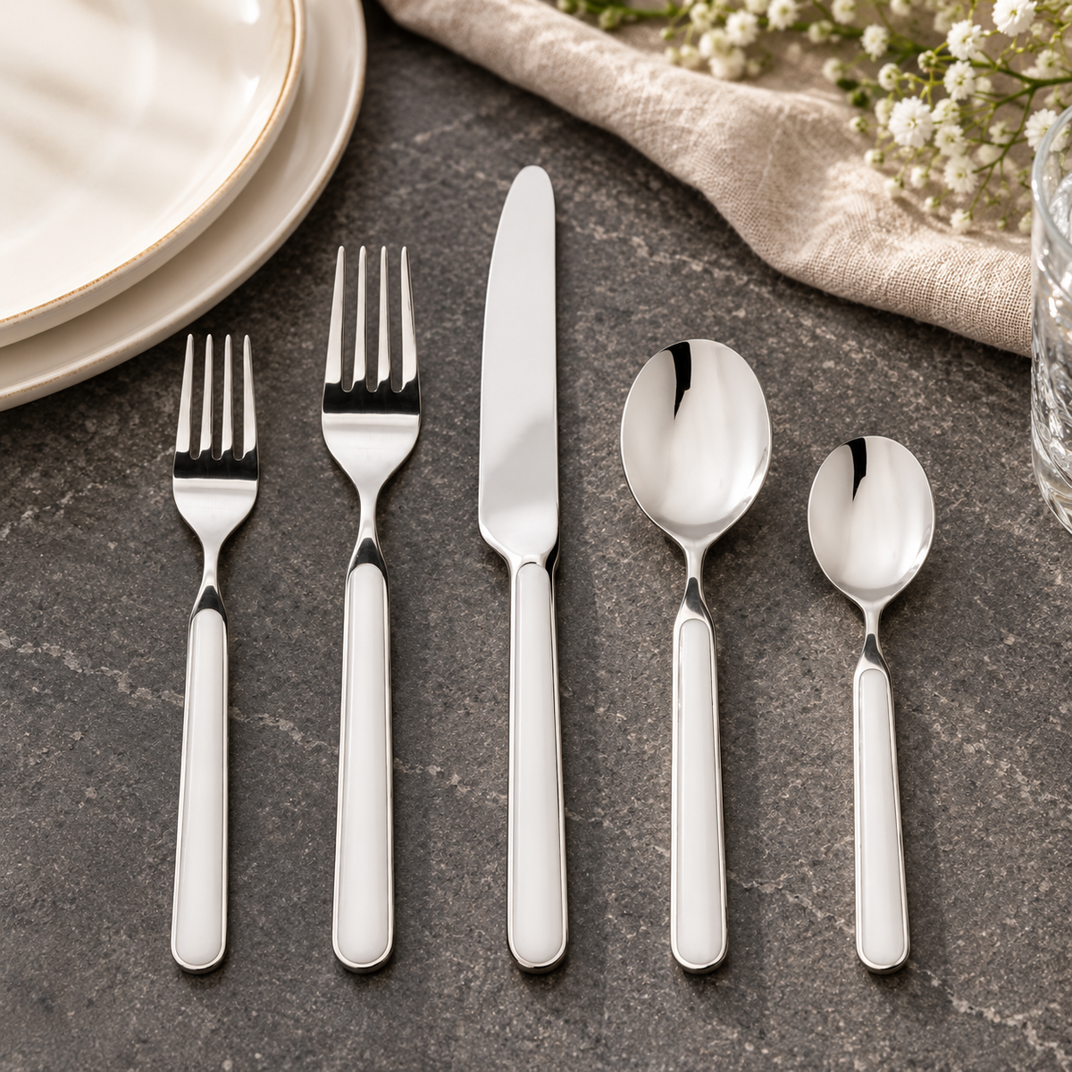 Mepra Fantasia China five-piece flatware on charcoal limestone