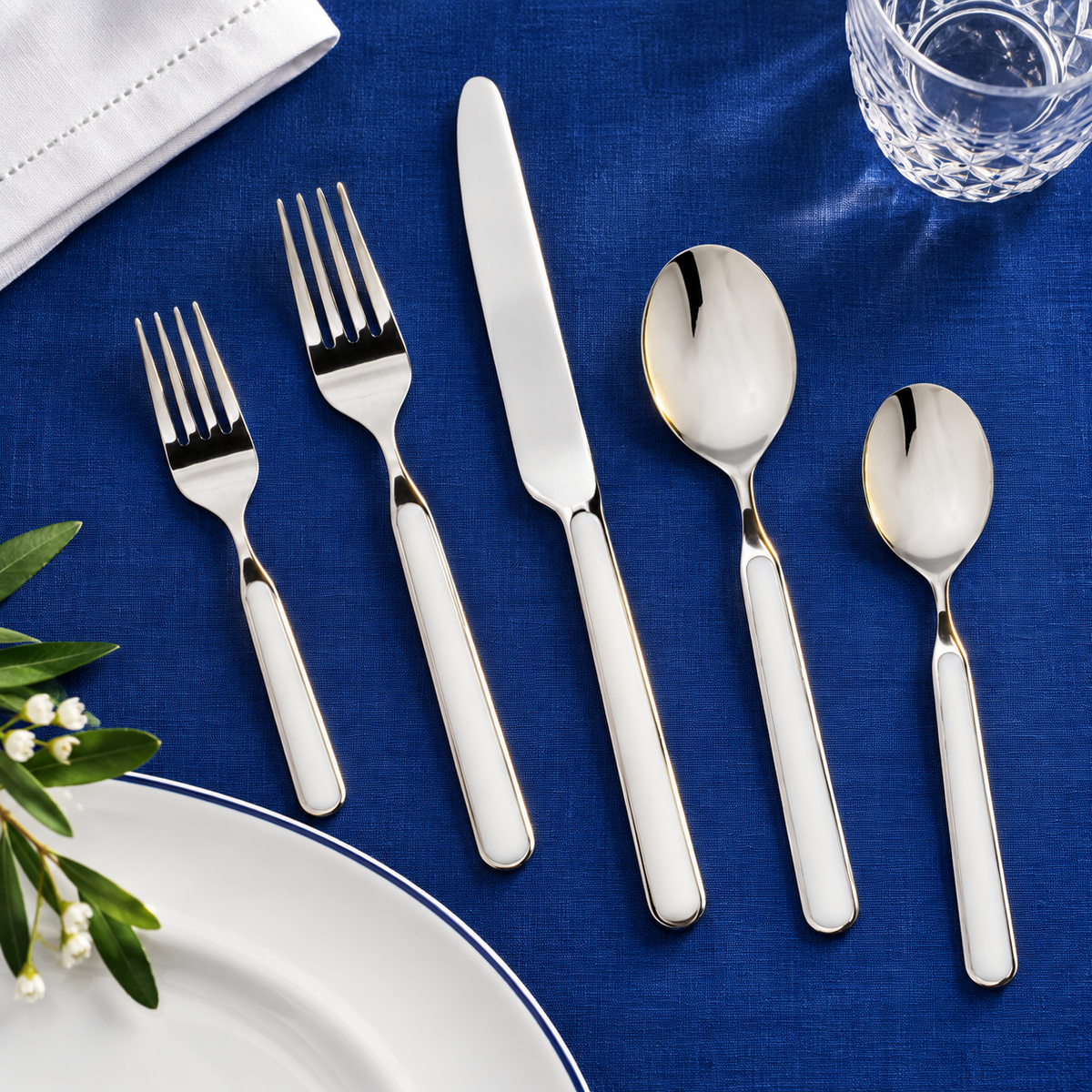 Mepra Fantasia China five-piece flatware on cobalt blue linen