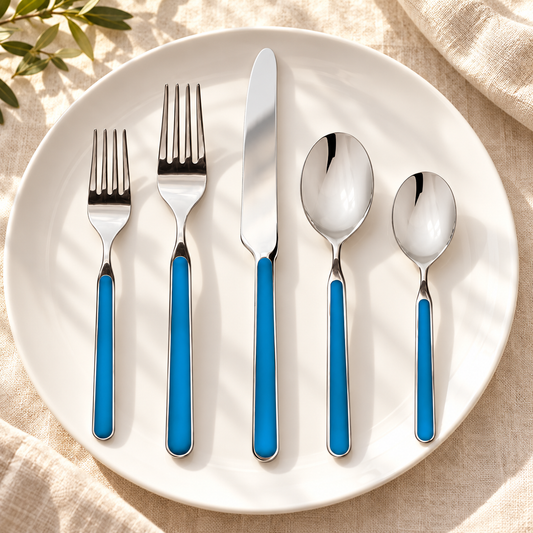 Mepra Fantasia Electric Blue five-piece flatware on cream linen and white plate