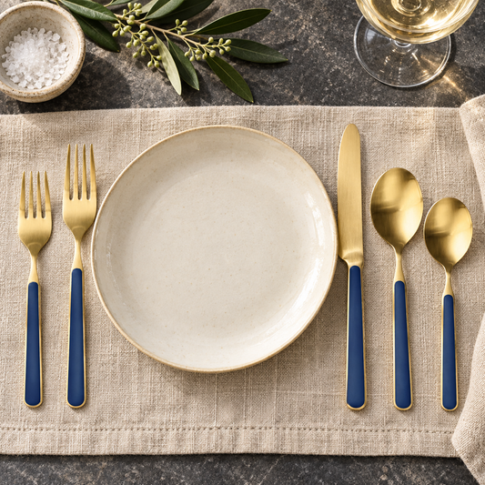 Mepra Fantasia Ice Oro Cobalt five-piece gold flatware around an ivory plate