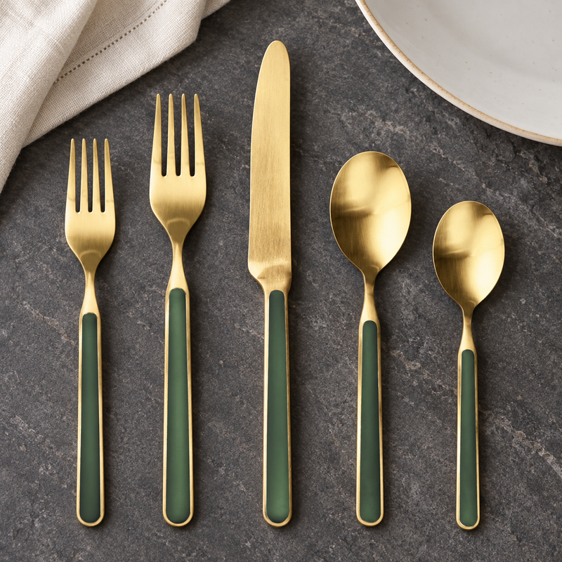 Mepra Fantasia Ice Oro Forest Green five-piece satin gold flatware on dark stone