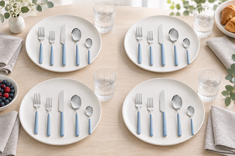 Mepra Fantasia Ice Oro Light Blue 20-piece flatware arranged as four airy Scandinavian place settings