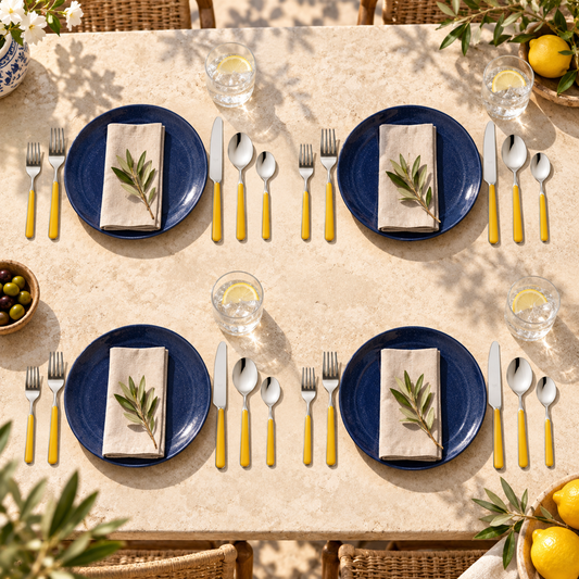 Mepra Fantasia Ice Oro Mustard 20-piece flatware arranged as four sunlit Mediterranean place settings