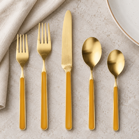 Mepra Fantasia Ice Oro Mustard five-piece satin gold flatware on pale stone